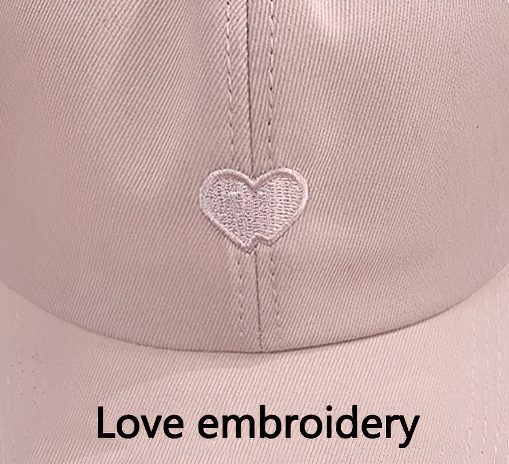 Close-up of a pink cotton baseball cap with heart embroidery, labeled 'Love embroidery' on the front.